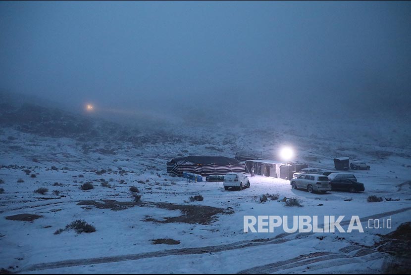 Musim Dingin Ekstrem Diperkirakan Melanda  Arab Saudi. Tenda didirikan di dekat mobil yang diparkir saat salju turun di Provinsi Tabuk, Arab Saudi.