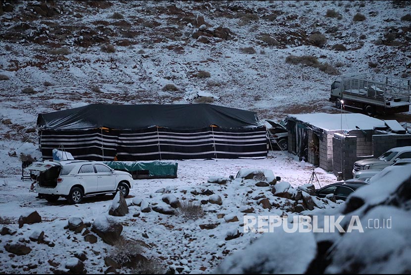 Tenda didirikan di dekat mobil yang diparkir saat salju turun di Provinsi Tabuk, Arab Saudi. Sebagian Arab Saudi Diprediksi Dilanda Badai Debu, Petir, dan Salju Hingga Jumat