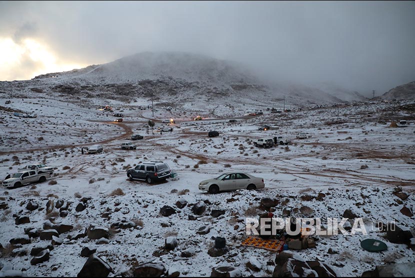 Tenda didirikan di dekat mobil yang diparkir saat salju turun di Provinsi Tabuk,Arab Saudi. Salju turun menyelimuti sejumlah wilayah di Arab Saudi  