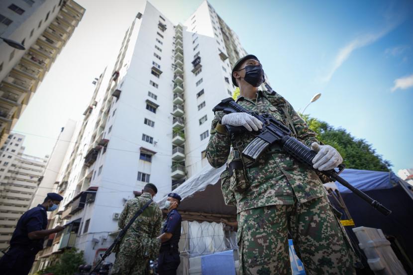 Tentara bersenjata berjaga di luar Pangsapuri Permai, daerah pemukiman yang ditempatkan di bawah perintah kontrol gerakan yang ditingkatkan (EMCO) karena peningkatan drastis jumlah kasus COVID-19 yang tercatat selama 10 hari terakhir di Cheras, pinggiran Kuala Lumpur, Malaysia, Jumat, 28 Mei 2021.