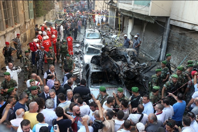  Tentara dan petugas penyelamat Lebanon beserta warga berkumpul di dekat lokasi pengeboman yang menewaskan delapan orang yang satu diantaranya adalah Kepala Departemen Penerangan Pasukan Keamanan Dalam Negeri Lebanon, Wissam El Hassan, Jumat (19/10). 