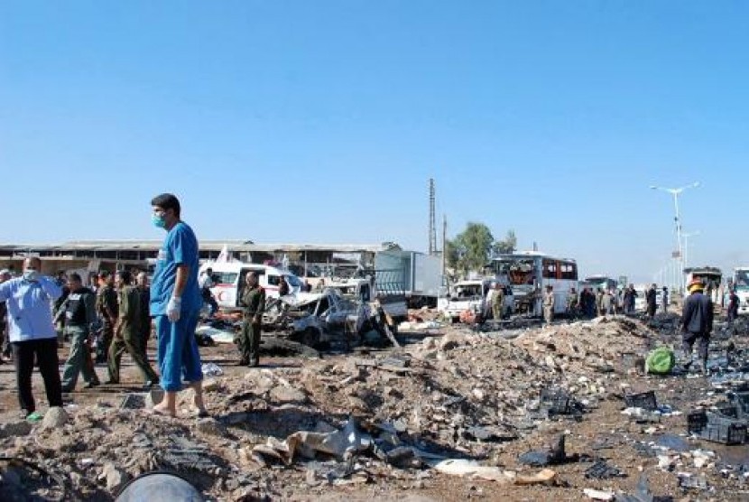 Tentara dan regu penyelamat saat memeriksa lokasi bom bunuh diri yang menewaskan 30 orang di Hama, Suriah