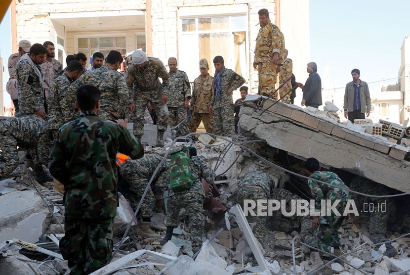 Tentara Iran mencari korban di bangunan yang hancur akibat gempa di kota Sarpol-e-Zahab di Provinsi Kermanshah, Iran, Senin (13/11). Gempa berkekuatan 7,2 besar melanda wilayah tersebut di sepanjang perbatasan antara Iran dan Irak pada (12/11), menewaskan sedikitnya 129 orang dan melukai lebih dari 300.