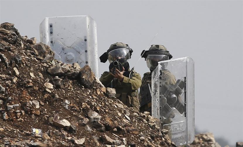  Tentara Israel bereaksi saat bentrok dengan warga Palestina di desa Kafr Qaddum, dekat kota Nablus, Tepi Barat, 23 Desember 2022. Bentrokan itu menyusul protes terhadap permukiman Israel di daerah tersebut. Israel Batalkan Proyek Perluasan Permukiman Menyusul Tekanan AS