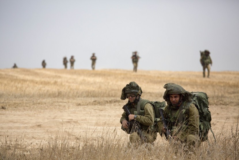 Tentara Israel berjalan saat memasuki perbatasan dengan Gaza, Selasa (22/7)
