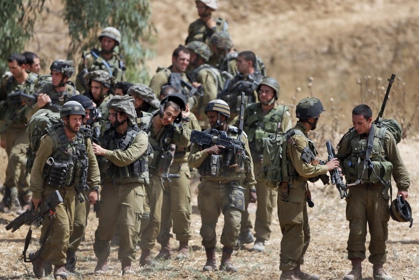 Tentara Israel bersiap untuk naik ke kendaraan lapis baja saat hendak masuk ke Gaza