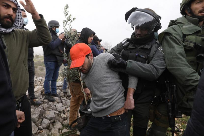 Tentara Israel menangkap seorang aktivis Israel untuk perdamaian di dekat pos permukiman di utara desa Palestina di Burin, dekat kota Nablus, Tepi Barat, 4 Februari 2022. 