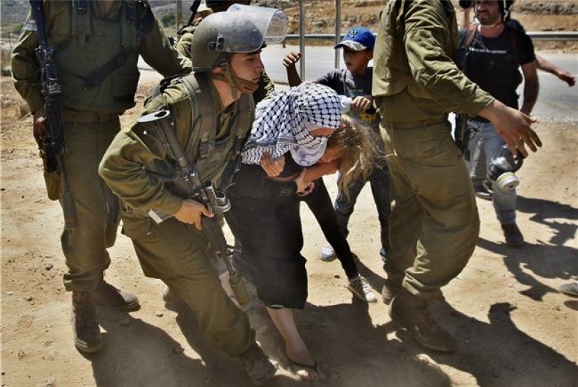  Tentara Israel menangkap seorang warga Palestina yang menggelar aksi protes di dekat pemukiman Yahudi di Halamish, Tepi Barat, Jumat (24/8). 