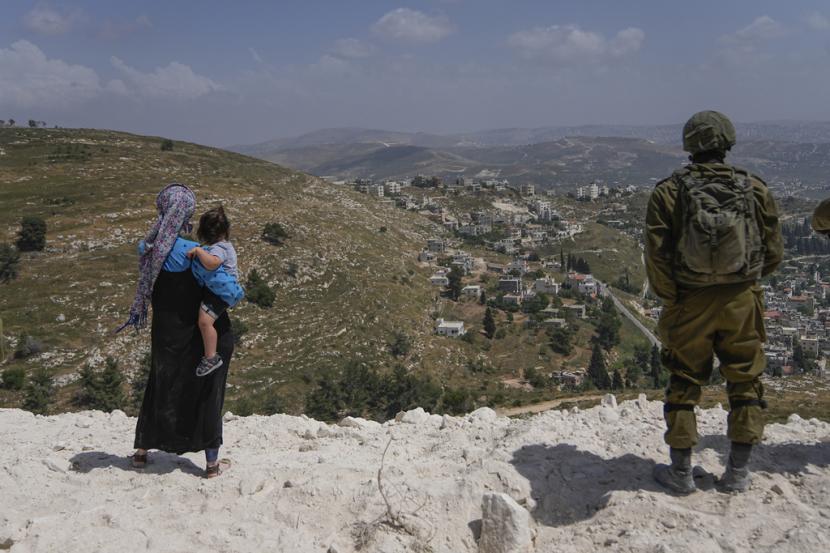 Tentara Israel mengamankan lokasi pembangunan saat para pemukim Yahudi bekerja di sebuah seminari yang dibangun semalam di pos terdepan Homesh Tepi Barat, Senin, 29 Mei 2023.