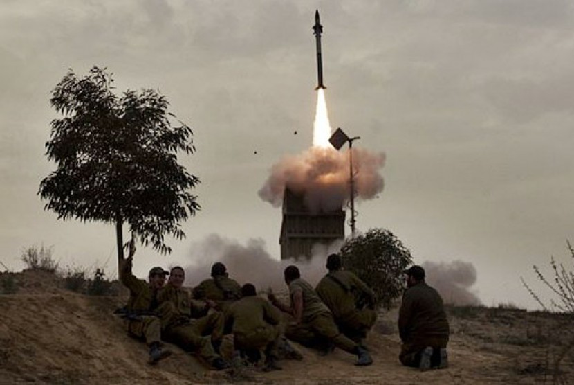 Tentara Israel sedang menyaksikan rudal yang diluncurkan dari sistem pertahanan rudal Iron Dome di selatan kota Beer Sheva. 