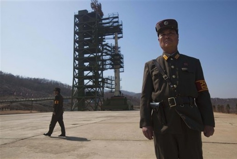 Tentara Korea Utara berjaga di depan roket Unha-3 yang siap diluncurkan di Stasiun Satelit Sohae, Tongchang-ri, Korea Utara, Ahad lalu (8/4).