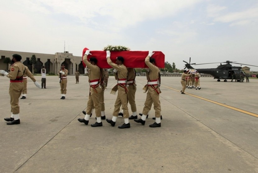 Tentara membawa peti jenazah yang dibungkus bendera merah putih Indonesia di Bandar Udara Nur Khan di Islamabad (9/5). Istri Dubes RI untuk Pakistan tewas setelah mengalami kecelakaan helikopter, Jumat (8/5).