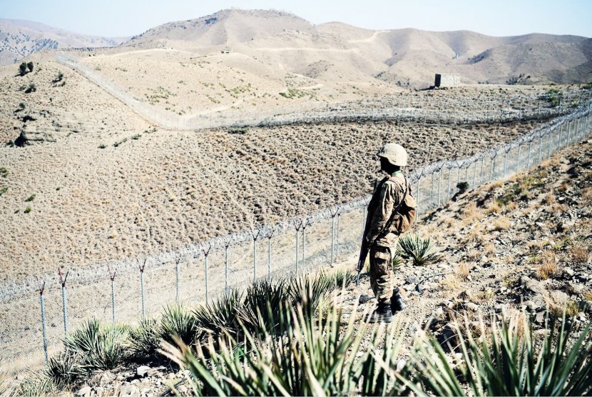 Tentara Pakistan berjaga di sepanjang pagar di perbatasan Afghanistan.
