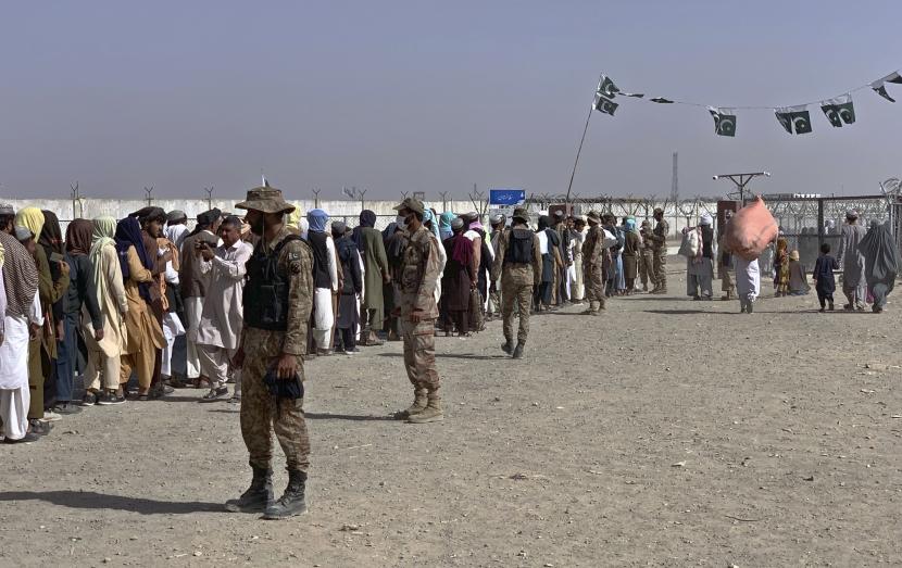Tentara Pakistan berjaga-jaga ketika warga Afghanistan dan Pakistan menunggu giliran untuk masuk ke Afghanistan melalui titik penyeberangan perbatasan, di Chaman, Pakistan, Sabtu, 21 Agustus 2021.
