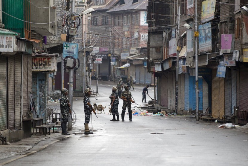 India Bawa 20 Diplomat Kunjungi Kashmir. Tentara paramiliter India berjaga di jalanan yang sepi saat jam malam di Srinagar, Kashmir yang dikuasai India.