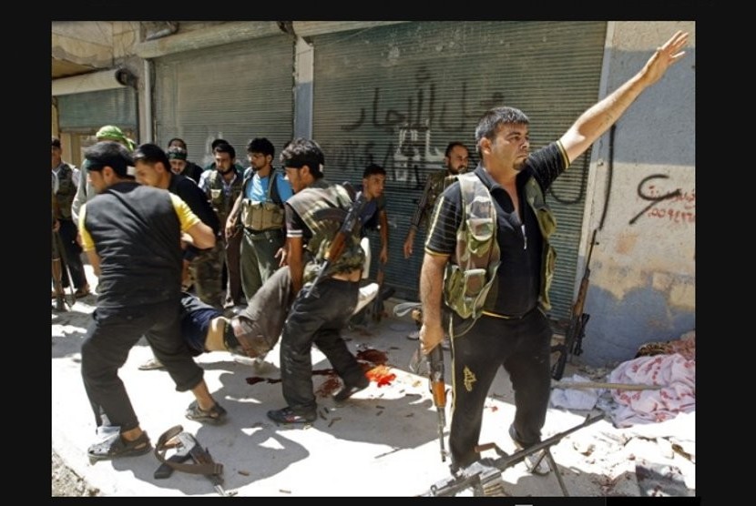 Tentara Pembebasan Suriah menggotong anggotanya yang tertembak saat bentrok dengan militer rezim di Aleppo (Goran Tomasevic/Reuters)