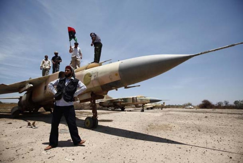 Tentara pemberontak berdiri di depan jet tempur Mig-23 di kota Misrata, Libya, dalam foto file yang diambil tanggal 28 Mei tahun 2011.