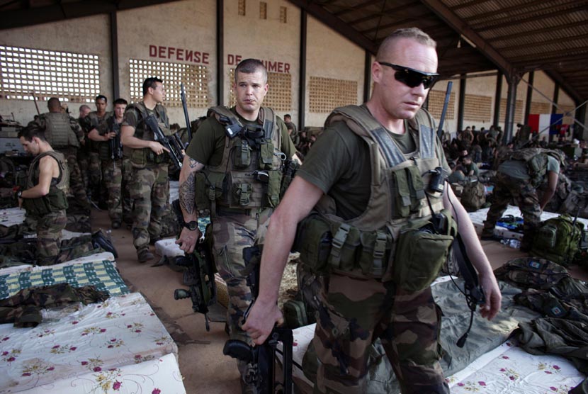 Tentara Prancis berjalan meniggalkan hanggar di pangkalan udara militer Mali di Bamako, Senin (14/1). (Reuters/Joe Penney)