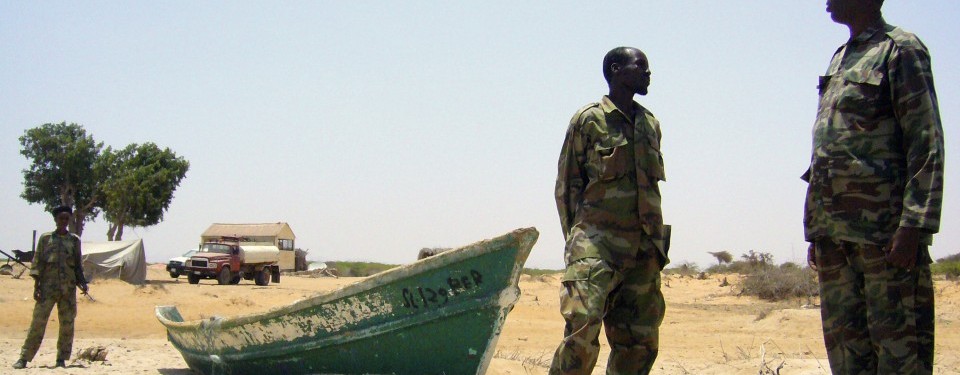 Tentara Somalia berjaga-jaga di garis pantai Milaxaar, 28 Maret 2011. Sebanyak 84 perompak sudah ditangkap sejak 2007 namun aksi ini terus merajalela. Perahu ini diduga milik perompak dan ada radio dari bantuan Inggris di dalamnya.