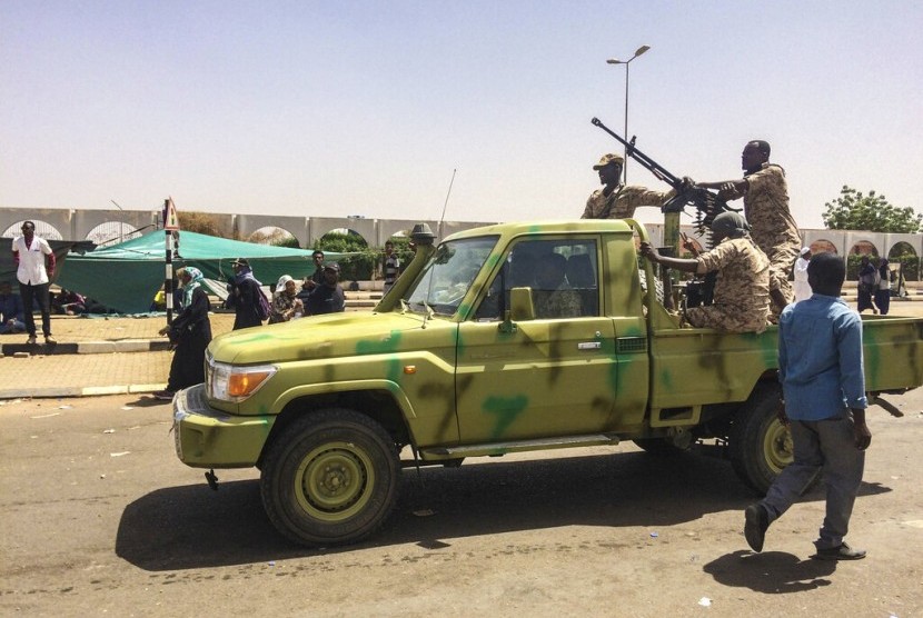 Tentara Sudan berpatroli sementara demonstran melakukan aksinya di dekat gedung Kementerian Pertahanan di Khartoum, Sudan, Selasa (9/4). 