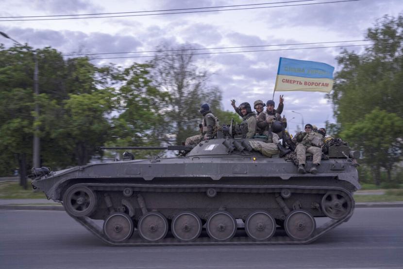 Tentara Ukraina mengibarkan bendera dengan tulisan dalam bahasa Ukraina 