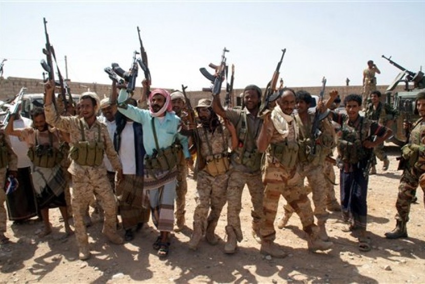 Tentara Yaman mengacungkan senjata di area yang berhasil direbut dari milisi Alqaidah di selatan Provinsi Shabwa, Kamis (8/5).