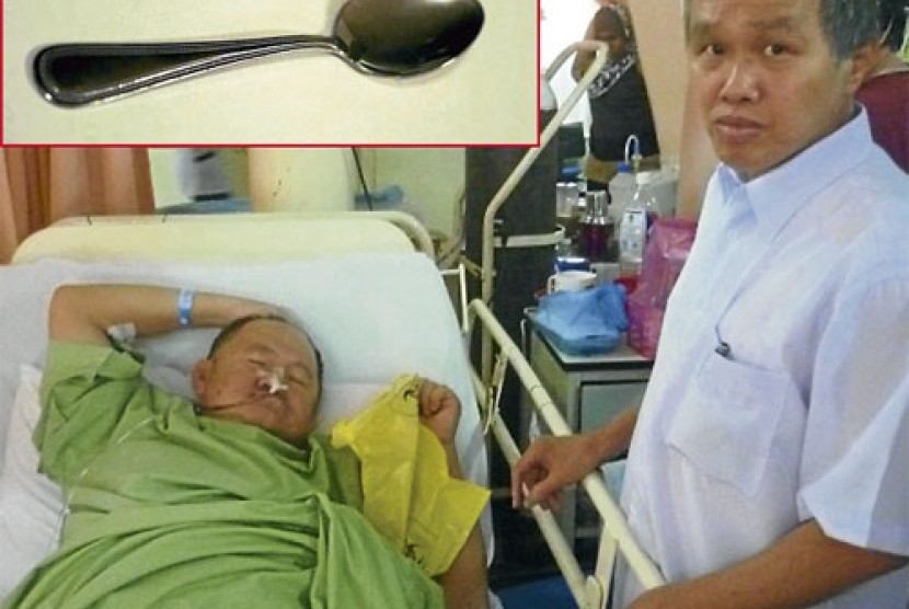Teoh Ah Lek terbaring di rumah sakit. Gambar atas merupakan sendok yang tertelan masuk perut Teoh Ah Lek. 