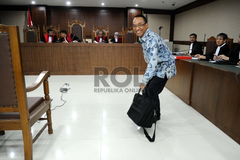 Terdakwa dugaan kasus penyalahgunaan wewenang dan korupsi, Jero Wacik mengambil tas saat akan mengikuti sidang di Pengadilan Tipikor, Jakarta, Senin (23/11). 