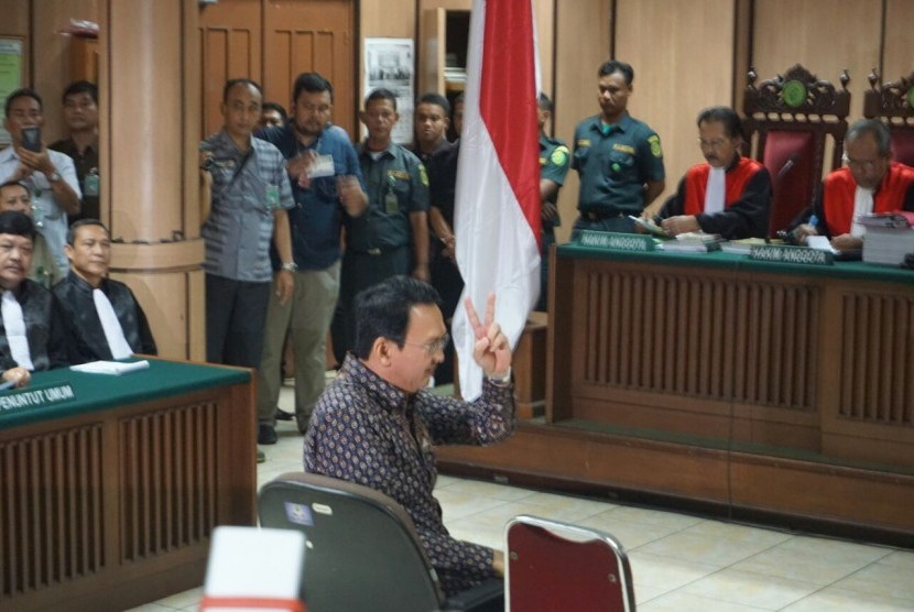 Terdakwa kasus dugaaan penistaan agama Basuki Tjahaja Purnama (Ahok) memberikan salam dua jari saat memasuki ruang sidang Koesumah Atmadja, Eks Gedung Pengadilan Negeri Jakarta Pusat, Selasa (27/12).