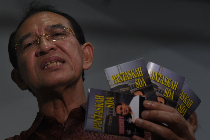 Terdakwa kasus dugaan korupsi dana haji Suryadharma Ali menunjukkan buku karyanya sebelum menjalani persidangan di Pengadilan Tipikor, Jakarta, Senin (11/1). 