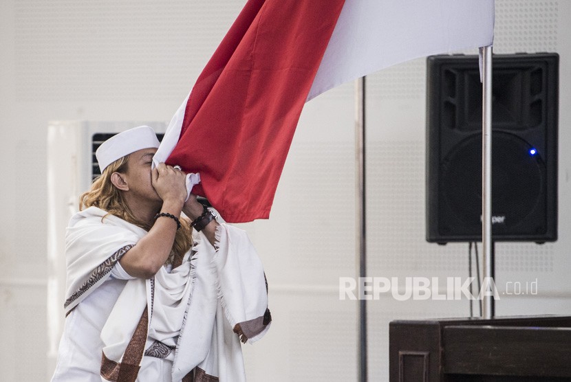 Terdakwa kasus dugaan penganiayaan terhadap remaja Bahar bin Smith mencium bendera Merah Putih seusai menjalani sidang putusan di gedung Arsip dan Perpustakaan, Bandung, Jawa Barat, Selasa (9/7/2019).