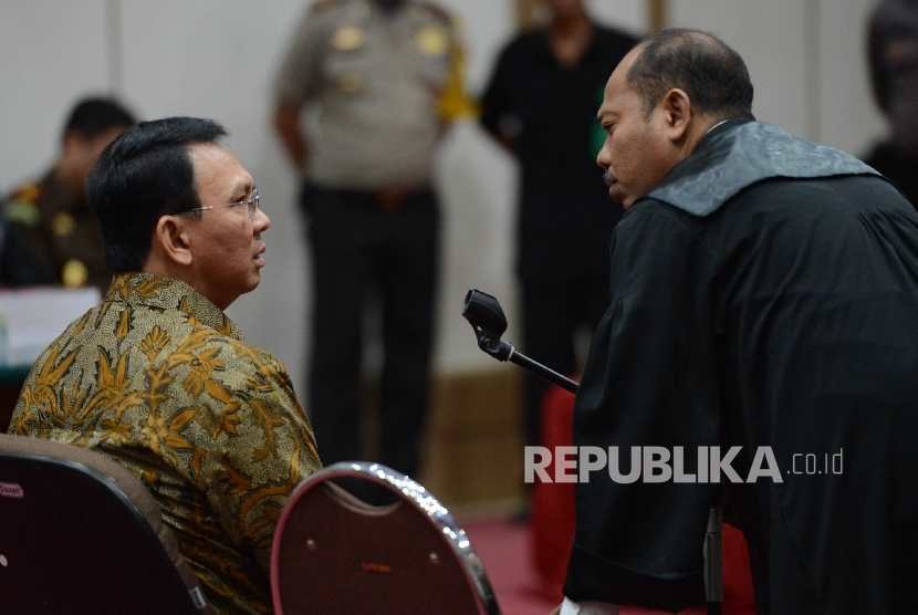  Terdakwa kasus dugaan penistaan agama Basuki Tjahaja Purnama berbincang bersama kuasa hukumnya saat menjalani sidang lanjutan dengan agenda pembacaan tuntutan di ruang auditorium Kementerian Pertanian, Jakarta, Selasa (11/4). 