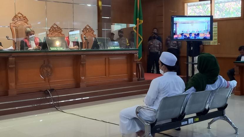 Terdakwa kasus dugaan penyebaran berita bohong Habib Bahar Bin Smith (kanan) tengah dan Tatan Rustandi yang mengunggah video ceramah Habib Bahar tengah mendengarkan majelis hakim yang membacakan putusan vonis di ruang sidang PN Bandung, Selasa (16/8/2022).