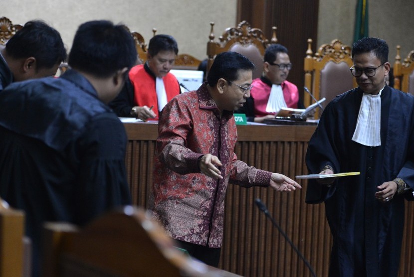 Terdakwa Kasus Korupsi Pengadaan KTP elektronik Setya Novanto menyerahkanbuku tentang dirinya kepada jaksa penuntut umum seusai membaca nota pembelaan pada sidang lanjutan di Pengadilan Tipikor, Jakarta, Jumat (13/4). 