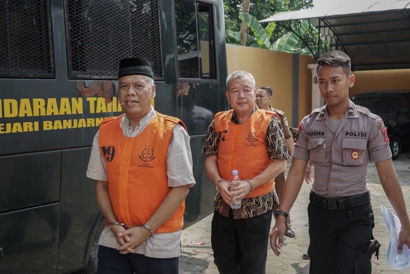 Terdakwa kasus mafia bola Dwi Irianto alias Mbah Putih (kiri) dan Tjan Ling Eng alias Johar Ling Eng (tengah), dikawal petugas menuju ruang sidang di Pengadilan Negeri Banjarnegara, Jateng, Senin (24/06/2019). 