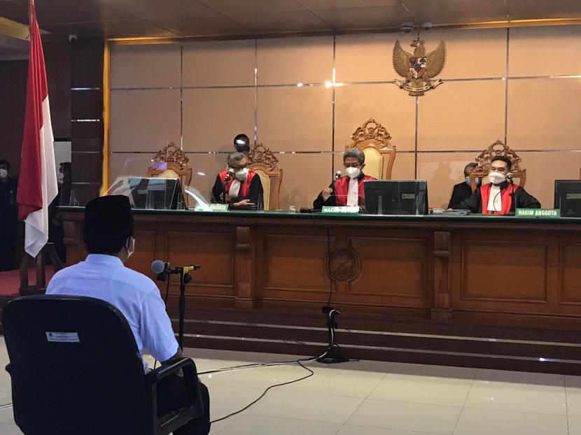 Terdakwa kasus pelecehan seksual terhadap 13 santriwati Herry Wirawan tengah mendengarkan pembacaan vonis yang dibacakan majelis hakim di PN Bandung, Selasa (15/2/2022). 