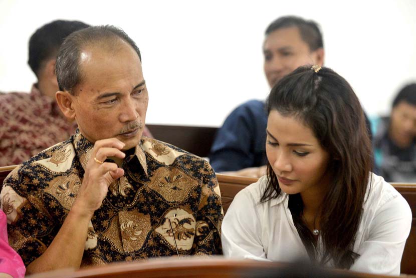 Terdakwa kasus pemberian FPJP dan penentuan Bank Century sebagai bank gagal berdampak sistemik, Budi Mulya (kiri) berbincang dengan putrinya Nadia Mulya (kanan) sebelum menjalani sidang dengan agenda pembacaan tuntutan di Pengadilan Tipikor, Jakarta, Senin