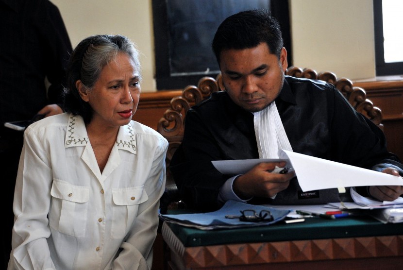 Terdakwa kasus pembunuhan anak, Margriet Megawe (kiri) berunding dengan penasihat hukumnya saat mendengarkan keterangan saksi dalam sidang di Pengadilan Negeri Denpasar, Senin (7/12). 