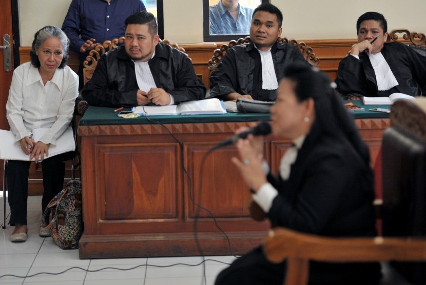 Terdakwa kasus pembunuhan Angeline, Margriet Megawe (kiri) mendengarkan keterangan saksi yang dihadirkan tim penasihat hukumnya dalam persidangan kasus pembunuhan Angeline di Pengadilan Negeri Denpasar, Senin (18/1).