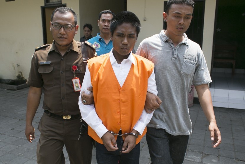 Terdakwa kasus pembunuhan Engeline, Agustay Hamba May (tengah) dikawal petugas saat akan menjalani sidang di Pengadilan Negeri Denpasar, Bali, Kamis (22/10).