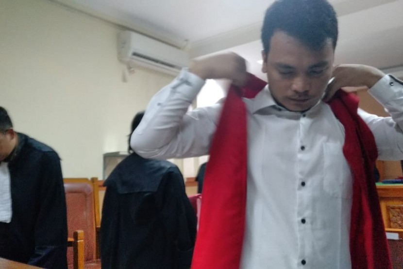 Terdakwa kasus pembunuhan satu keluarga di Bekasi, Haris Simamora, sedang memasang rompi tahanan usai melaksanakan sidang perdananya di Pengadilan Negeri Bekasi, Senin (11/3).