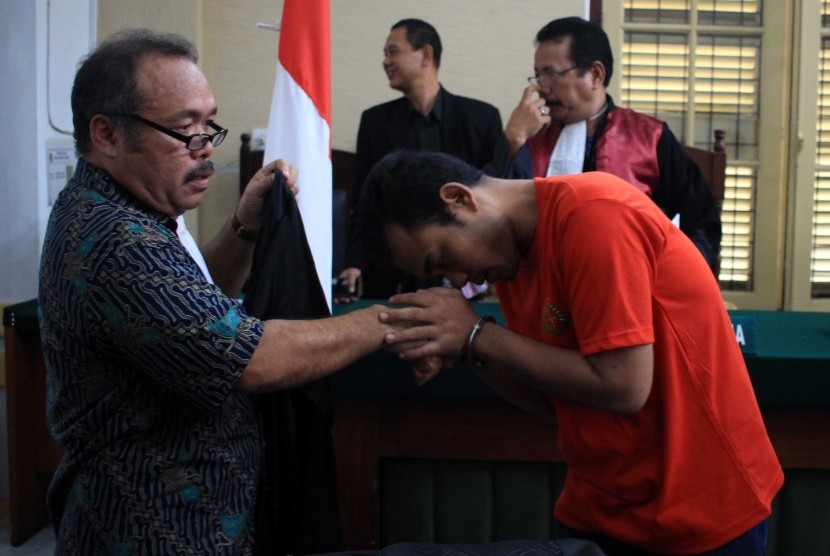 Terdakwa kasus pembunuhan sekeluarga Andi Lala (kanan) menyalami jaksa penuntut umum usai mengikuti sidang dengan agenda pembacaan tuntutan di Pengadilan Negeri Medan, Sumatera Utara, Jumat (29/12). 