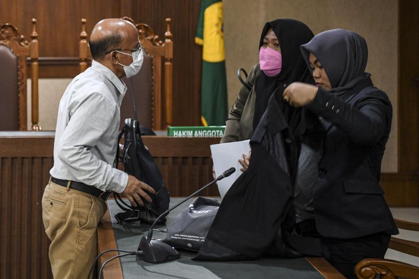 Terdakwa kasus suap pajak Wawan Ridwan (kiri) berbincang dengan kuasa hukumnya usai menjalani sidang pembacaan putusan di Pengadilan Tipikor.