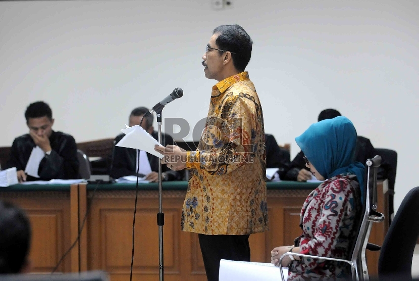 Terdakwa kasus suap sengketa pilkada yang juga mantan Walikota Palembang Romi Herton (kiri) bersama istrinya Masyitoh (kanan) bersiap mengikuti sidang dengan agenda pledoi terdakwa di Pengadilan Tipikor, Jakarta, Senin (23/2).