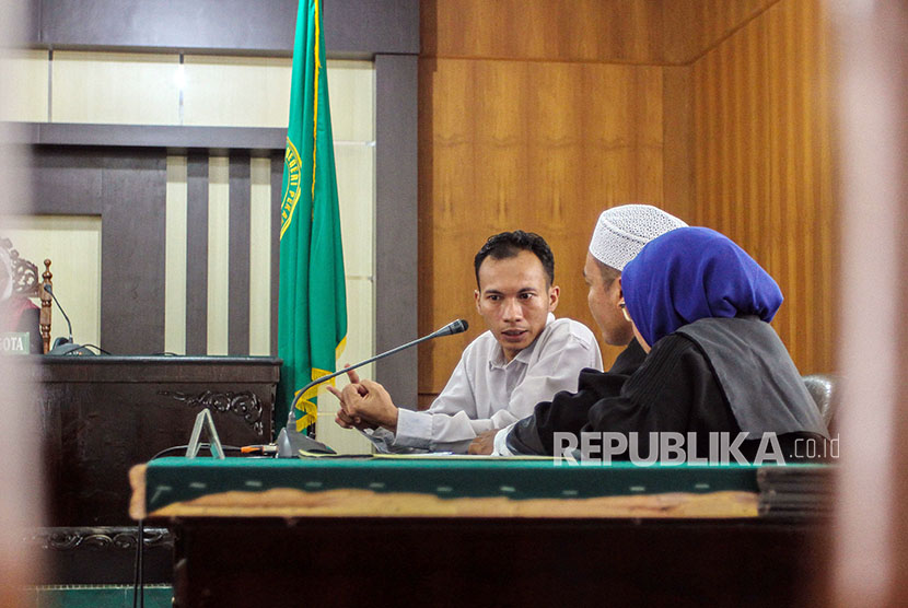 Terdakwa penyebar ujaran kebencian Jasriadi (Saracen Grup) berdialog dengan penasihat hukum usai mendengarkan pembacaan vonis di Pengadilan Negeri (PN) Pekanbaru, Jumat (6/4).