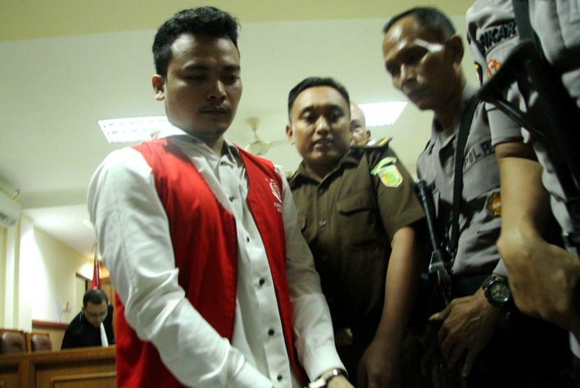 Terdakwa tindak pidana kasus pembunuhan satu keluarga Haris Simamora (kiri) berdiri meninggalkan ruang sidang di Pengadilan Negeri Bekasi, Bekasi, Jawa Barat, Senin (13/5/2019). 