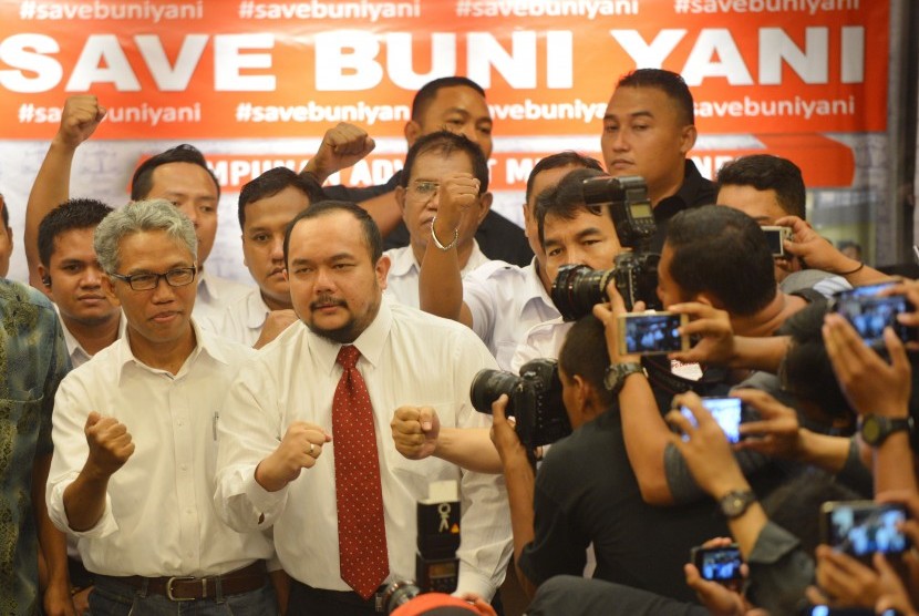 Terlapor kasus dugaan pengeditan video Ahok, Buni Yani (kiri) bersama pendukungnya mengepalkan tangan sebelum memberikan konferensi pers di Jakarta, Senin (7/11).