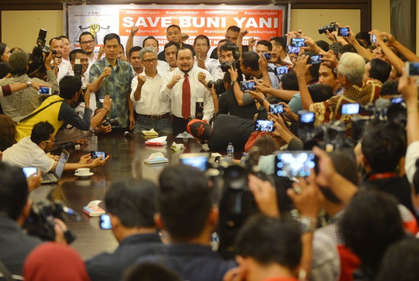 Terlapor kasus dugaan pengeditan video Ahok, Buni Yani (tengah) bersama pendukungnya mengepalkan tangan sebelum memberikan konferensi pers di Jakarta, Senin (7/11).