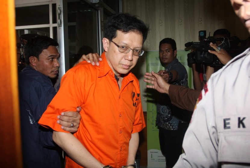 Terpidana kasus korupsi Bank Century Hartawan Aluwi (tengah) dikawal petugas kepolisian saat tiba di Kejagung, Jakarta, Jumat (22/4). 