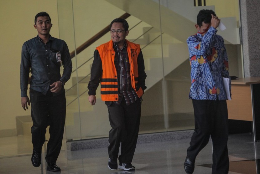 Tersangka Auditor Utama Keuangan Negara (AKN) III Badan Pemeriksa Keuangan (BPK) Rochmadi Saptogiri (tengah) meninggalkan Gedung KPK seusai menjalani pemeriksaan di Jakarta, Rabu (6/9). 